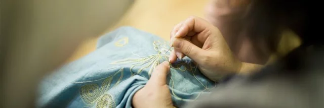 Atelier broderie d'Art avec Pascal Jaouen
Gros plan sur des mains cousant un motif de broderie, une expérience bretonne